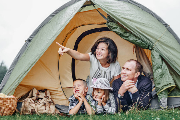 Family Parents and two children in camp tent. Happy Mother, father, son and daughter on Summer vacation. - Foto, immagini