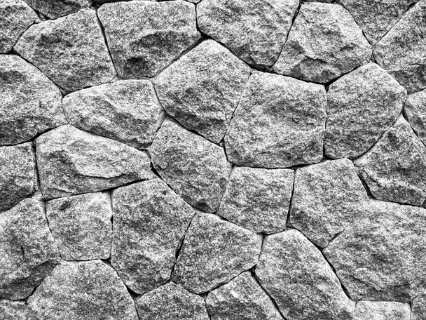 Konsystencja kamiennej ściany tła. Abstrakcyjna powierzchnia ciemnoszarej skały o różnym kształcie. - Zdjęcie, obraz