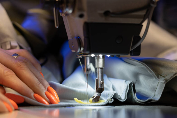 Εργασίες ραφής σε ραπτομηχανή, κοντινό πλάνο. Γυναίκα σχεδιαστής μόδας δημιουργούν νέα ρούχα συλλογή - Φωτογραφία, εικόνα
