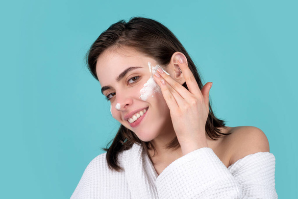 Woman beauty face, portrait of beautiful female model apply a cleansing mask on face. Skincare and healthy skin, spa facial treatment concept. - Fotó, kép