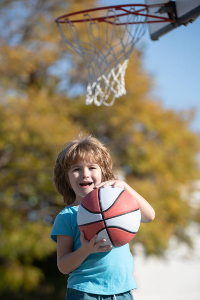 Cute child playing basketball laughing and having fun. - Zdjęcie, obraz