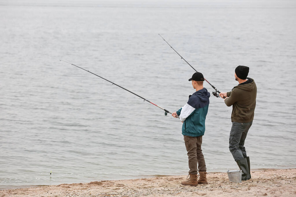 Padre e hijo pescando juntos en el río
 - Foto, Imagen
