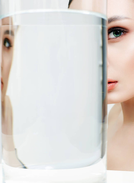 beautiful girl and her reflection in glass with water. clean skin young woman. Beauty Fashion Portrait - Photo, Image