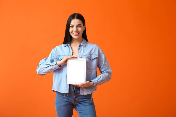 Young woman with tablet computer on color background - Foto, Imagen