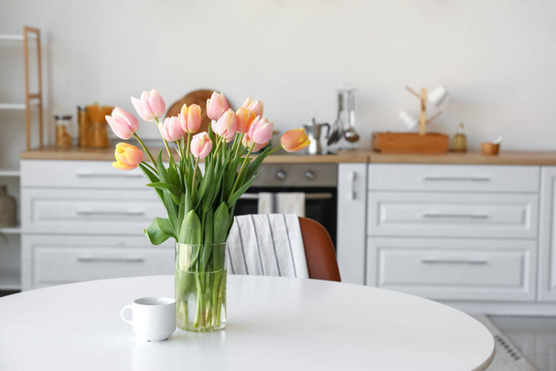Boeket van mooie tulp bloemen op tafel in de keuken - Foto, afbeelding