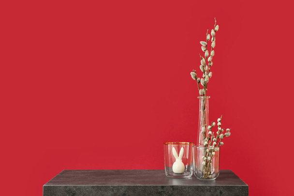 Vázy s vrbovými větvemi na stole u barevné stěny - Fotografie, Obrázek