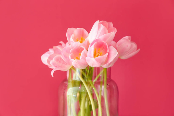 Vase mit schönen Tulpenblumen auf farbigem Hintergrund - Foto, Bild