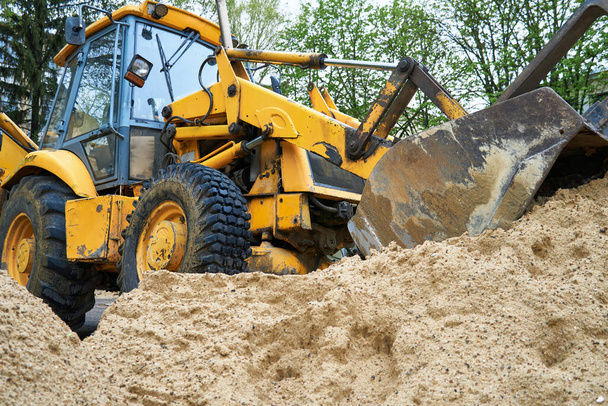 Prace ciągnika lub buldożera ze stosem piasku do budowy - Zdjęcie, obraz