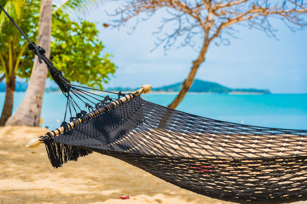 Altalena vuota del hammock intorno all'oceano del mare della spiaggia con cielo blu bianco della nuvola per le vacanze di corsa - Foto, immagini
