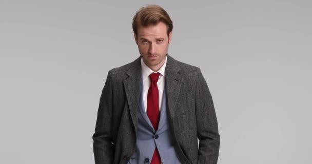 sexy uomo d'affari posa con le mani in tasca, chiudendo il cappotto e facendo un segno ok - Filmati, video