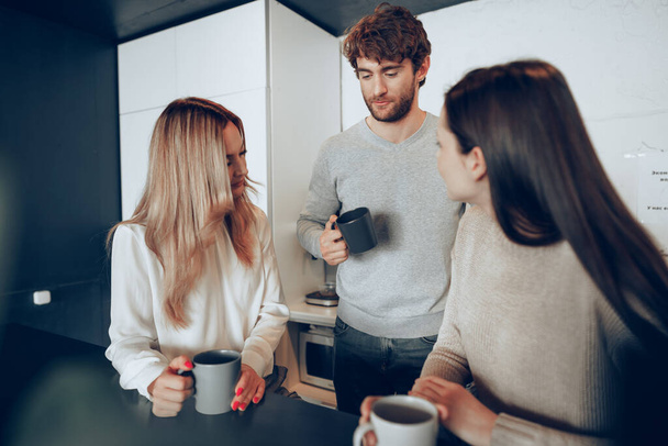 Mladí podnikatelé kolegové mají přestávku na kávu v kanceláři, pití a mluvení - Fotografie, Obrázek