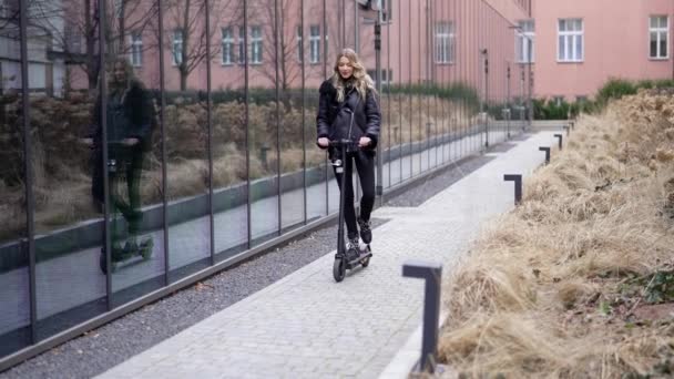 ブロンドの女性はスクーターに乗って顔を作る - 映像、動画