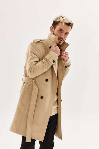 férfi bézs kabát divat vonzó megjelenés fény háttér - Fotó, kép