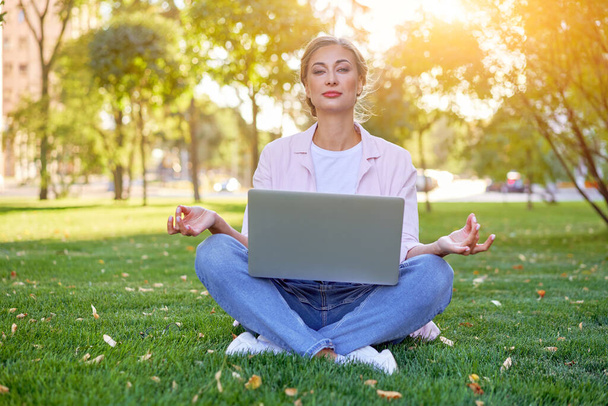 Businesswoman sitting grass summer park using laptop Business person working remote. Outdoor Successful european caucasian woman freelancer make video call teacher study work online lessons  - Photo, Image