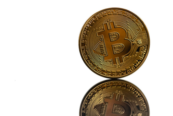 Closeup golden bitcoin with reflection isolated on white background. Bitcoin is reflected in the mirror. - Photo, Image