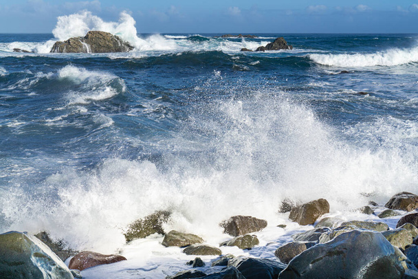 El áspero Océano Atlántico cerca de Tenerife, España, fuertes olas rompen en las rocas en el agua - Foto, Imagen