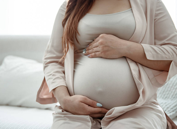 Primo piano di una grande pancia di una donna negli ultimi mesi di gravidanza. - Foto, immagini