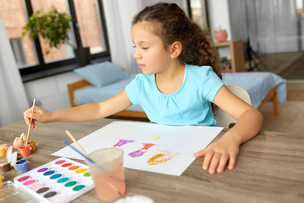 little girl with colors drawing picture at home - Foto, imagen