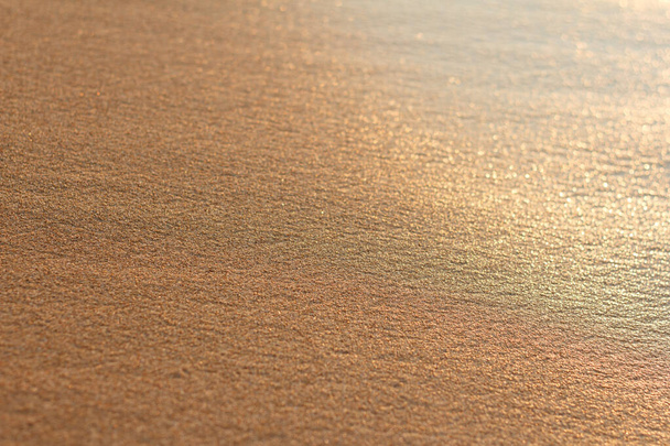 Hermosa arena marina con incluso textura de superficie húmeda a la luz del sol de la mañana - Foto, Imagen