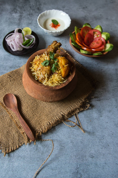 Popular Indian mughlai delicacy chicken biryani in an earthen pot with use of selective focus. Top view. - Photo, Image