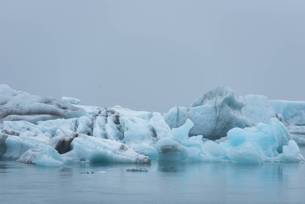 Jéghegyek olvadnak a globális felmelegedés és a Jokulsarlon gleccserlagúnában lebegő klímaváltozás következtében. Vatnajokull Nemzeti Park, Izland - Fotó, kép