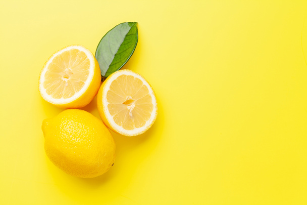 Fresh ripe lemons on yellow background. Top view flat lay with copy space - Fotó, kép