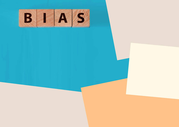 het woord bias op houten blokken blauwe achtergrond. - Foto, afbeelding
