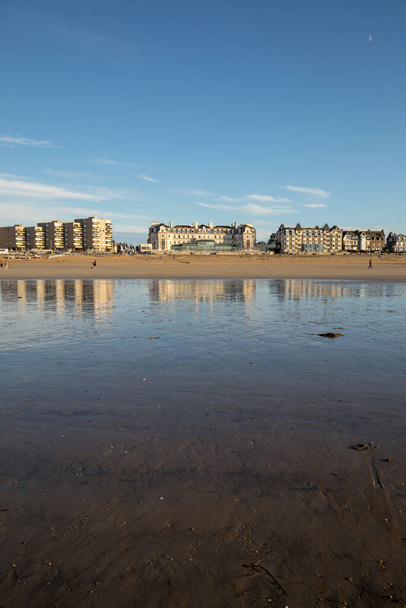 St Malo, France - September 16, 2018: Beach in the evening sun and buildings along the seafront promenade in Saint Malo. Brittany, France - Photo, Image