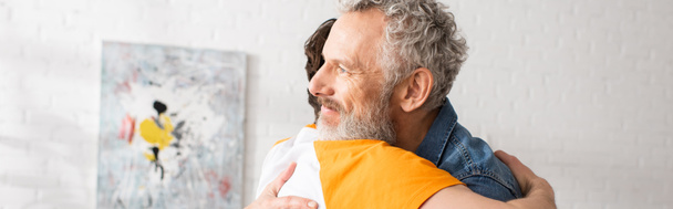 Middelbare man knuffelen zoon thuis, banner  - Foto, afbeelding