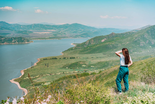 Jeune femme debout contre fond bleu mer et montagnes Kazakhstan oriental - Photo, image