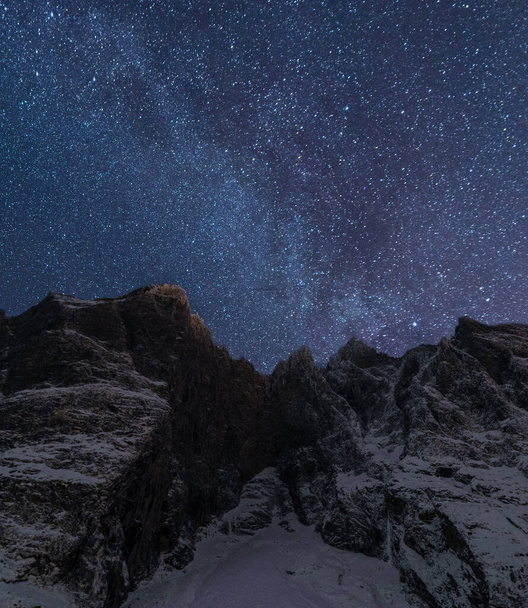 A vertical shot of the Trollveggen in Romsdal, Norway under a starry night sky - 写真・画像