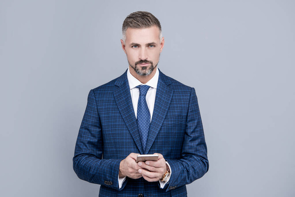 confident businessman man in suit typing text message on phone, blogging. - Photo, Image