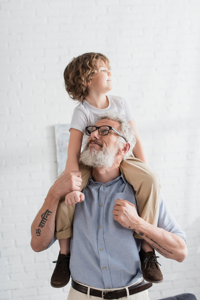 Mature man holding grandson at home  - Foto, Imagem
