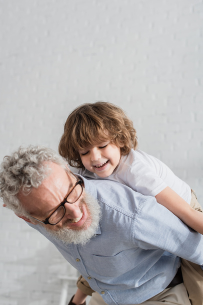 Smiling man and grandson playing at home  - Foto, imagen