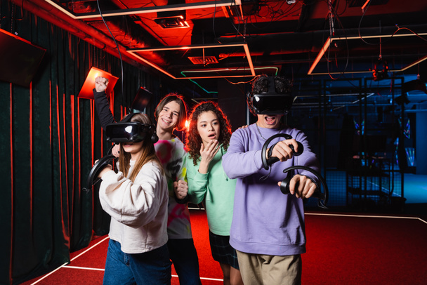 amazed african american girl covering mouth with hand near friends in vr game room - Fotoğraf, Görsel