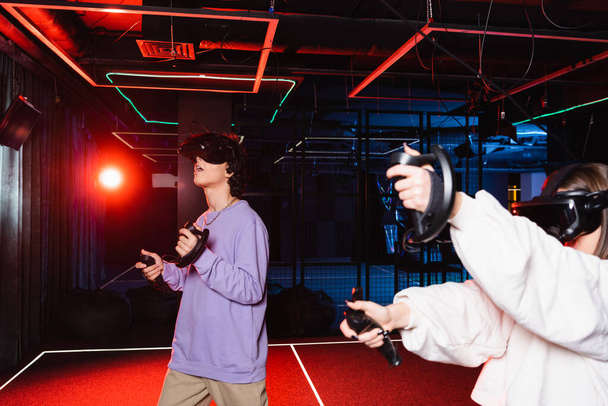 astonished guy in vr headset gaming near friend in play zone - Foto, immagini