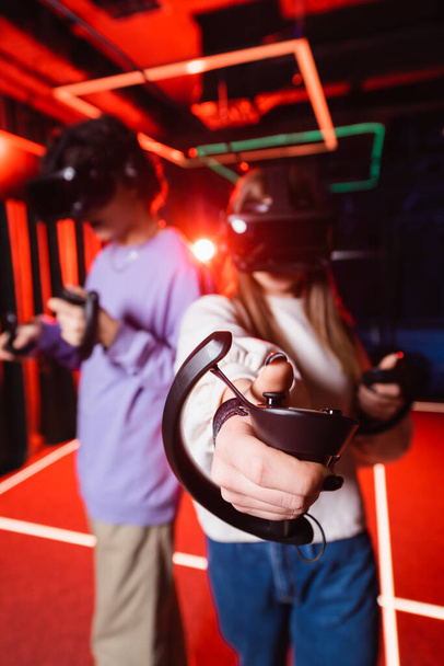 blurred teenagers in vr headsets gaming in play zone - Photo, Image