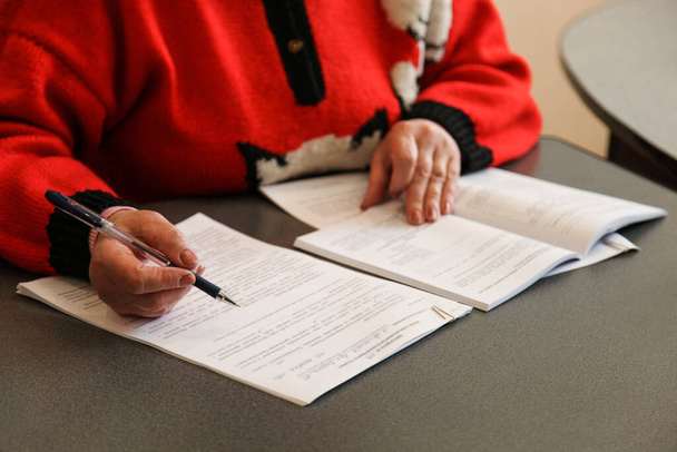 Η γυναίκα εξετάζει τα έγγραφα. Υπογράφω συμβόλαιο. Επιχειρηματική έννοια - Φωτογραφία, εικόνα