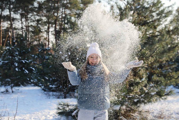 Woman playing with snow in winter forest - Photo, Image