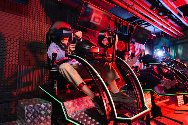 teenage friends gaming in car racing simulators in vr play zone - Photo, Image