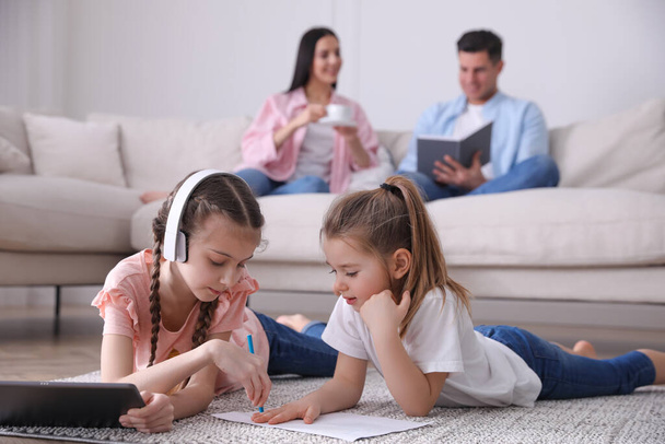 Family in living room with comfortable sofa, focus on children - Fotoğraf, Görsel