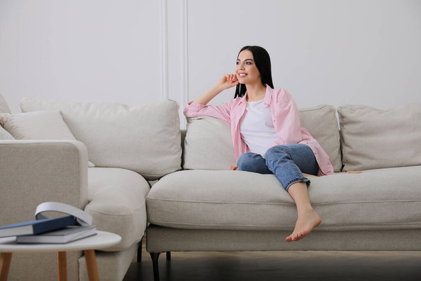 Woman resting on sofa in living room - Photo, Image