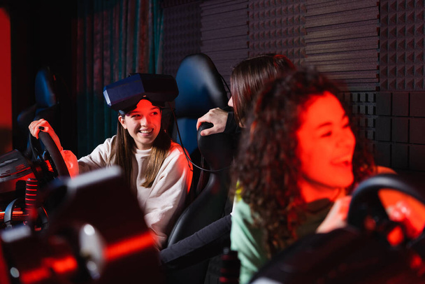 african american girl laughing near friends and car racing simulators - Photo, Image