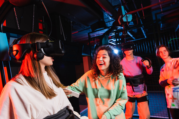 excited african american girl laughing near friends gaming in vr headsets - Fotó, kép