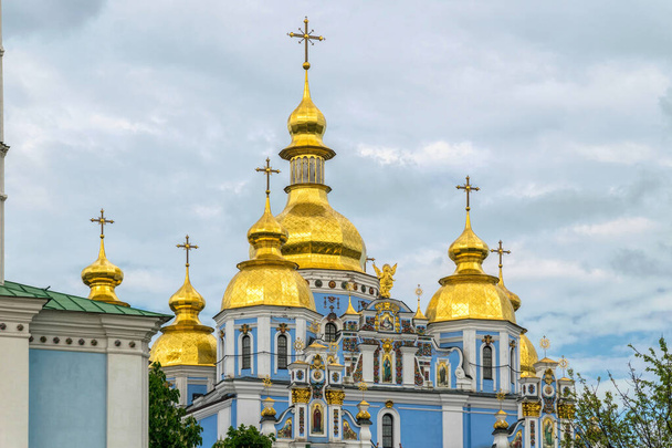Kijów, Ukraina - 14 maja 2021: majestatyczna katedra św. Michała w Kijowie i wieczorne niebo. Słynny zabytek w Rusi Kijowskiej. Starożytne chrześcijańskie cerkwie ze złotymi kopułami - Zdjęcie, obraz