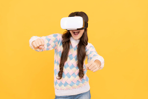 szczęśliwa nastolatka nosi bezprzewodowe okulary VR. za pomocą zestawu słuchawkowego VR. Dzieciak gra w gry wideo. Cyfrowa przyszłość i innowacje. dziecko w goglach wirtualnej rzeczywistości. nowoczesna technologia bezprzewodowa. rozwój dzieciństwa. - Zdjęcie, obraz