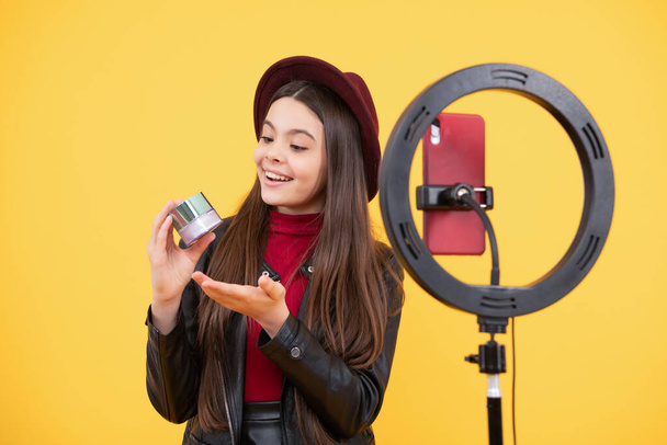 blogger adolescente feliz uso selfie llevó la lámpara y el teléfono inteligente en el trípode para hacer video tutorial en línea belleza blog presentando cosméticos de maquillaje, moda. - Foto, imagen