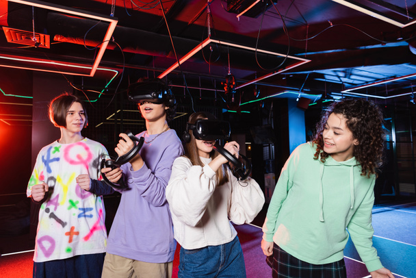 cheerful interracial friends spending time in vr play room - Photo, Image