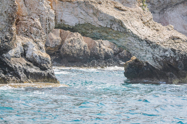 A small strait with azure water near the rocks in Cyprus - Φωτογραφία, εικόνα