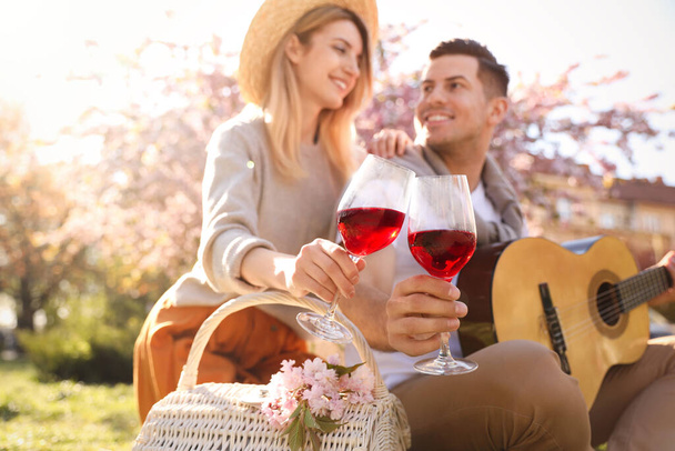 Lovely couple having picnic in park, focus on hands with glasses of wine - Foto, afbeelding
